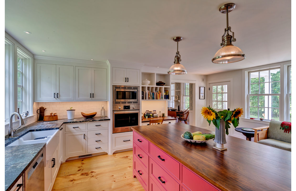 large kitchen with a wooden island with painted red cabinets