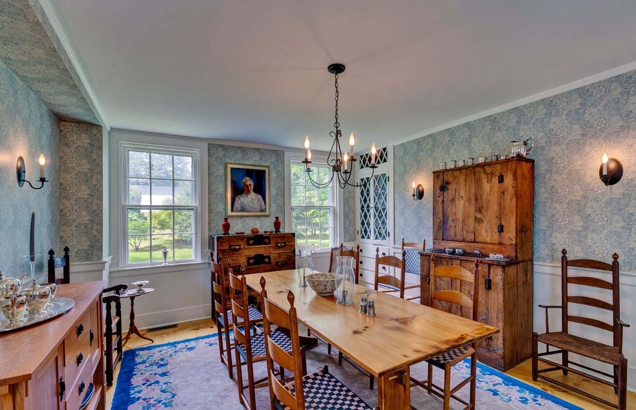dining room with wooden farmhouse-style furniture and light blue wallpaper