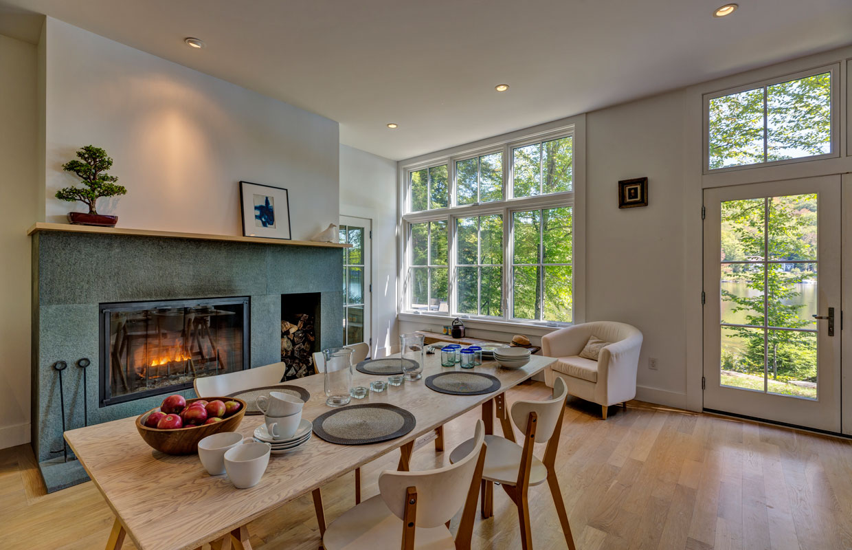 dining room table with a fireplace and large windows