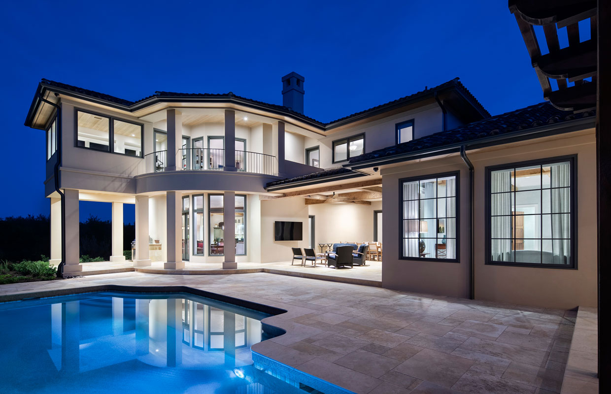 large white modern home with a pool at night