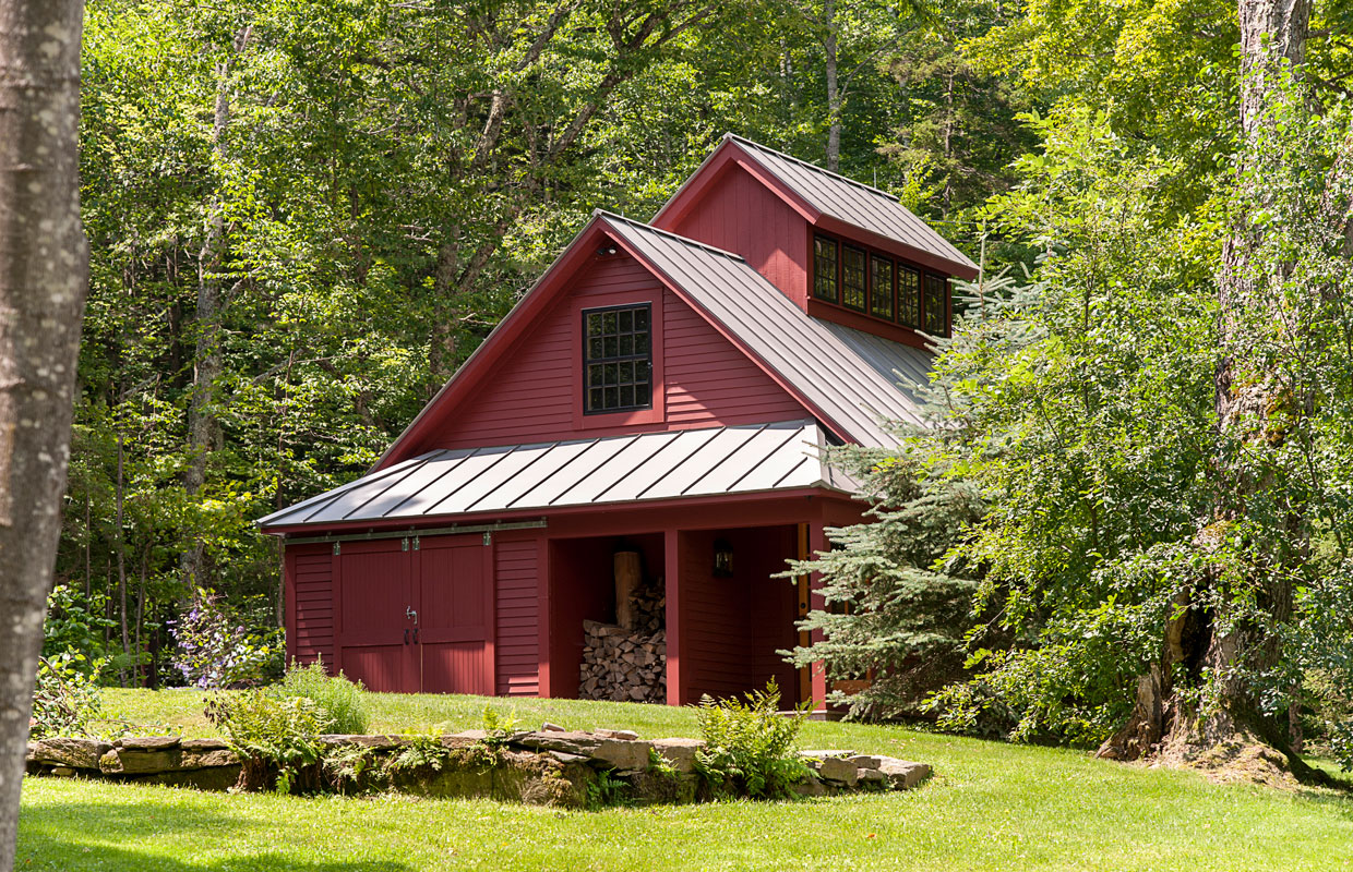 red building in the woods with lush green grass