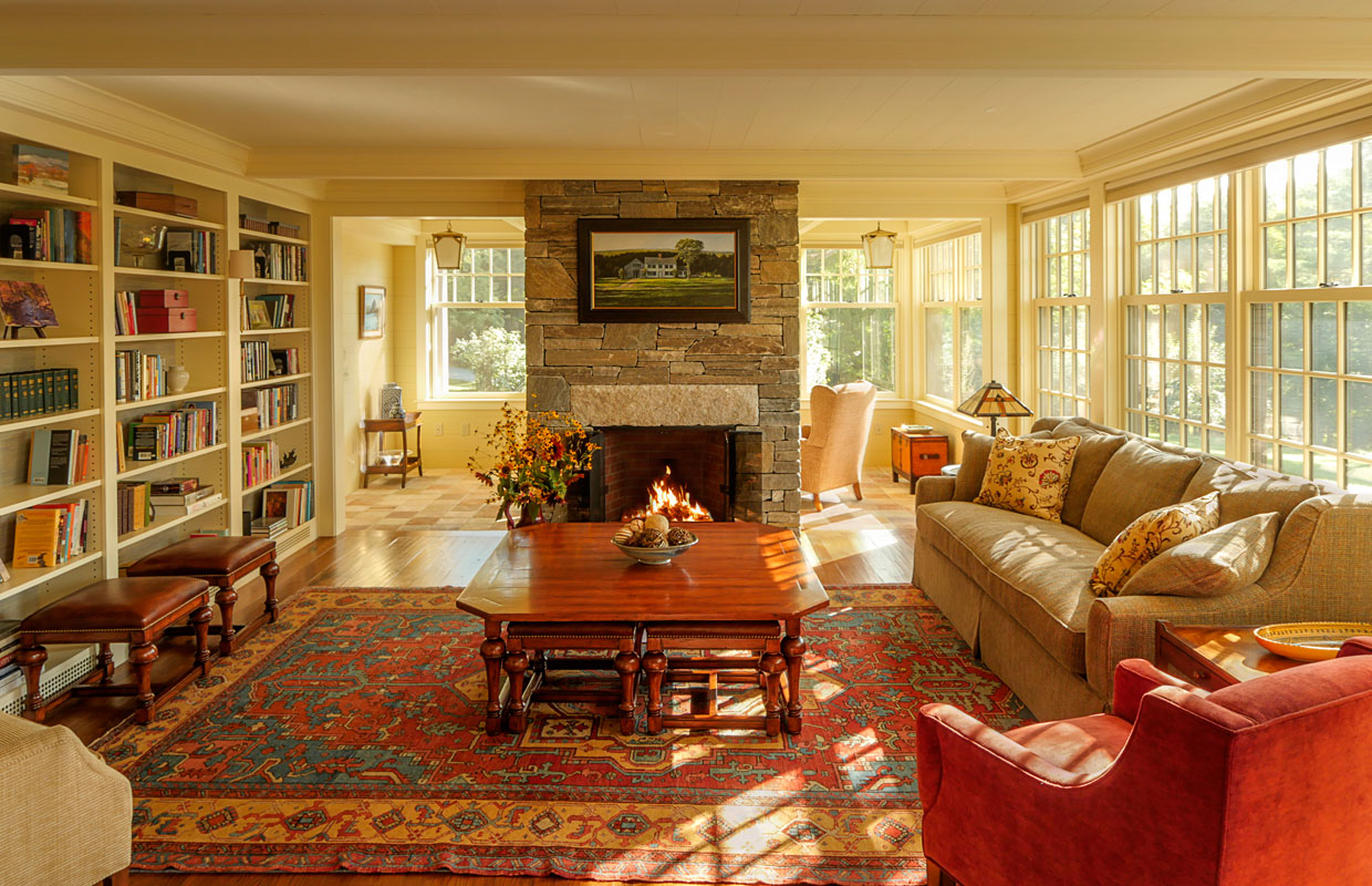 living room with a fireplace and large red ornate rug