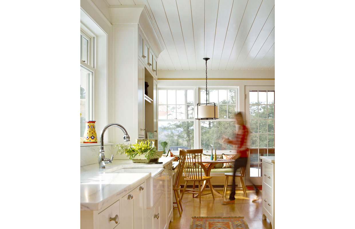 kitchen with a which ceiling and a person walking by blurred in motion
